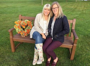 two women sitting on a bench talking about support for cancer patients
